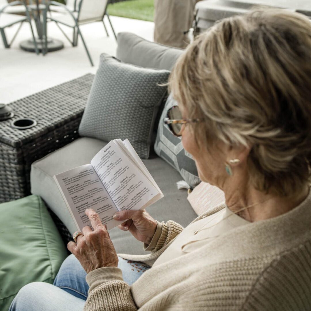 Woman reading a book on patio