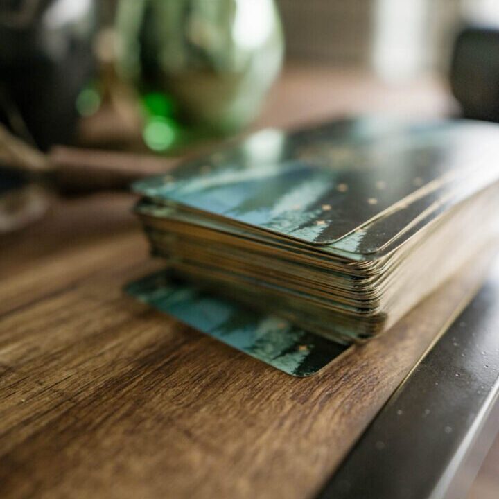 A stack of vintage photographs on a wooden table.